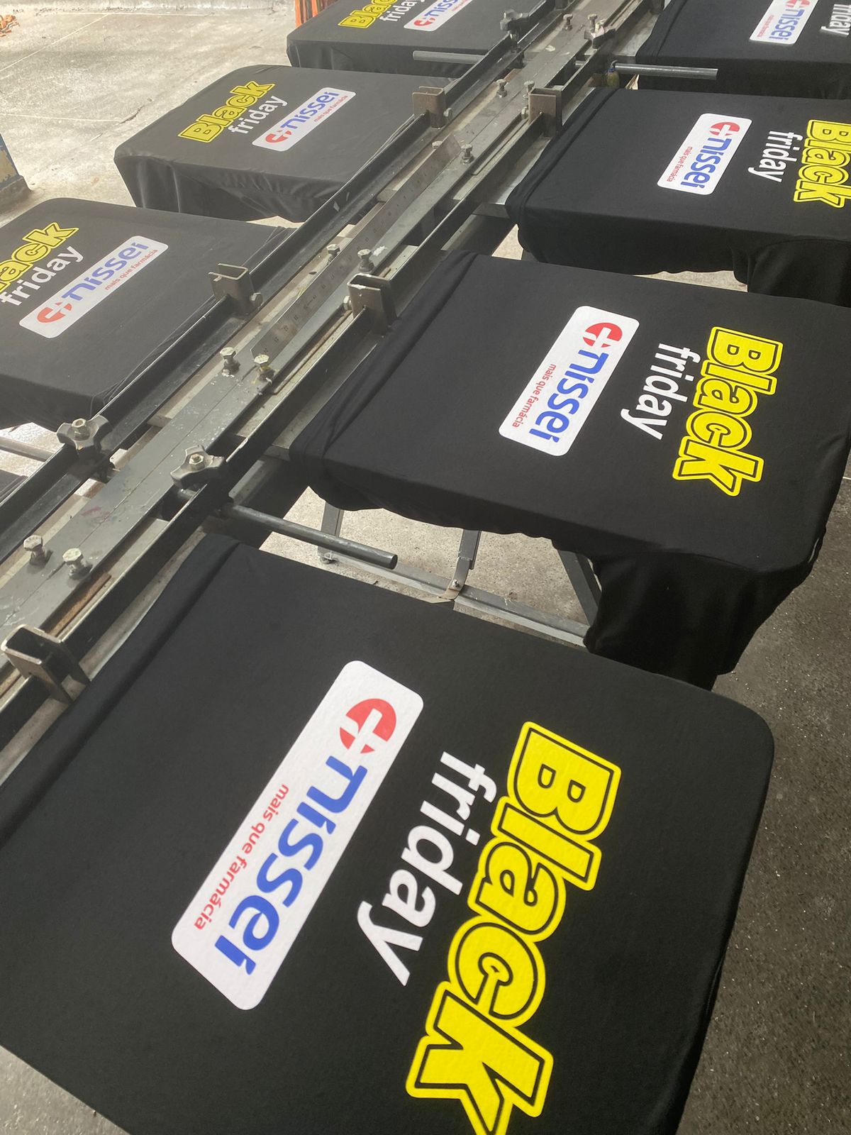 Produção de camisetas Nissei na prensa de serigrafia — fábrica Veloz Uniformes Curitiba